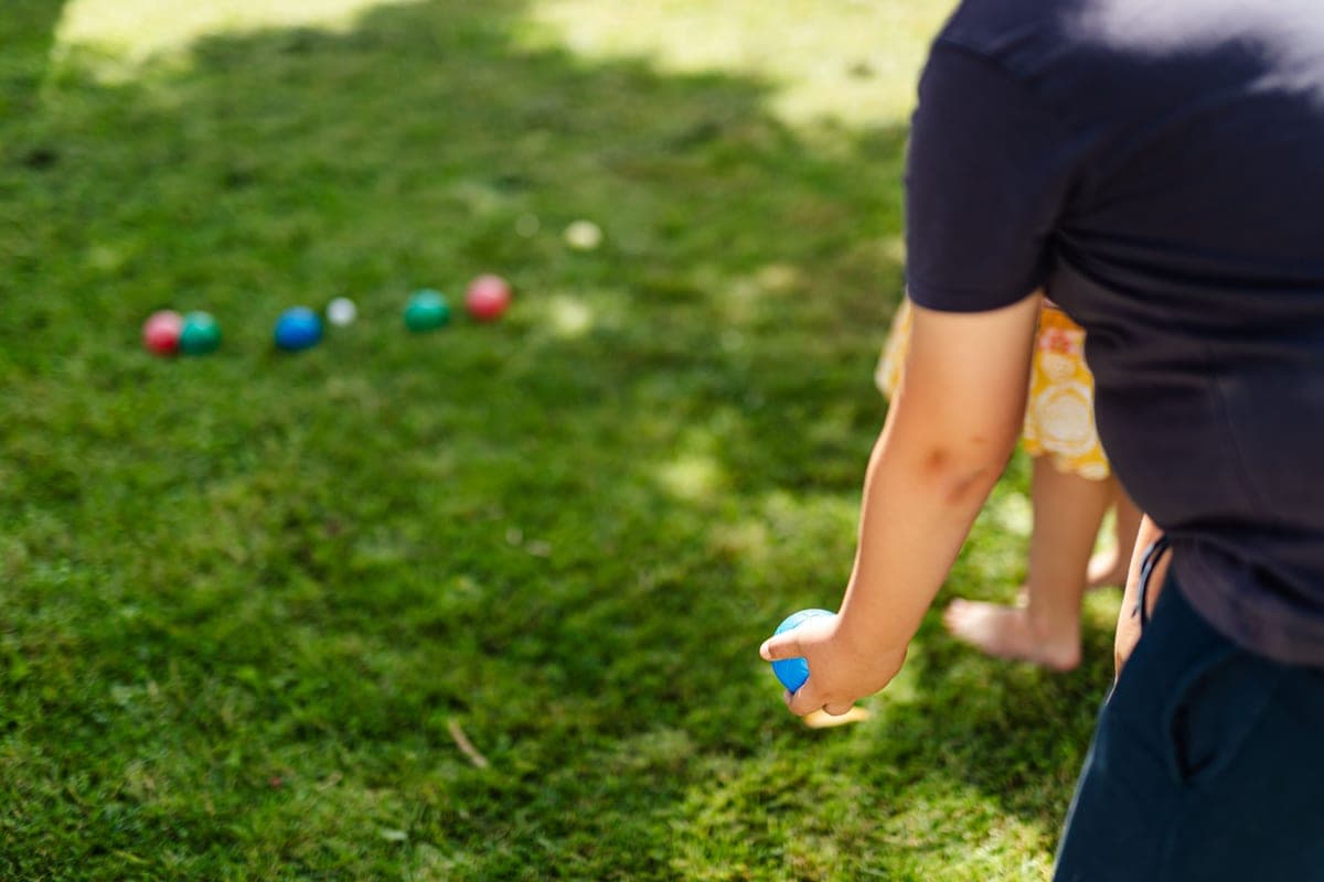 Bocce balls on a lawn beside a wooden lawn game