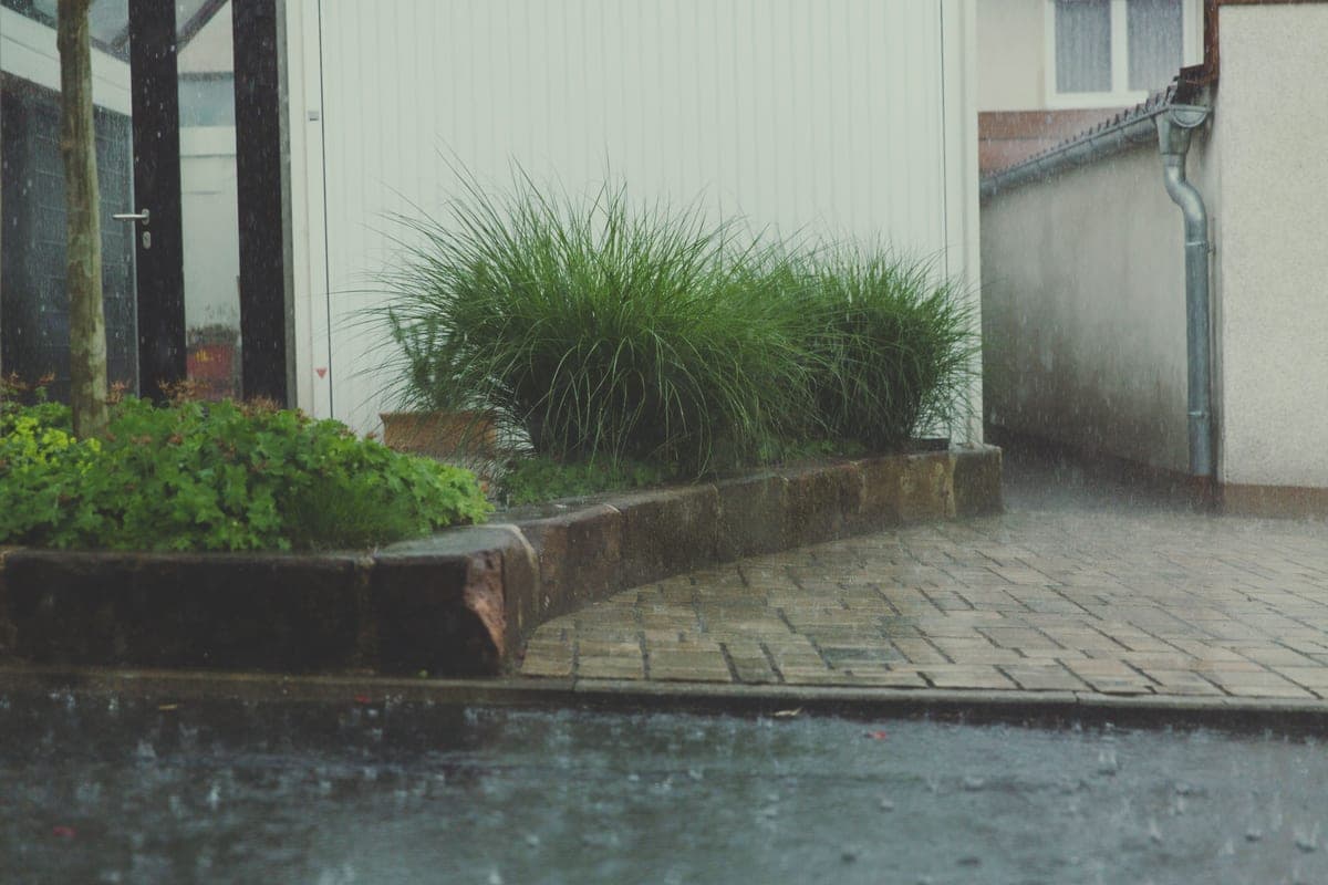 Rain falling on garden furniture and a wet lawn