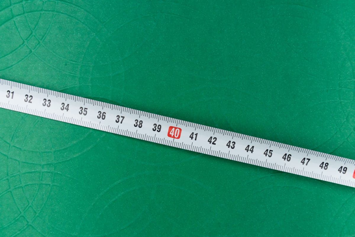A tape measure laid out on a lawn for measuring a game court