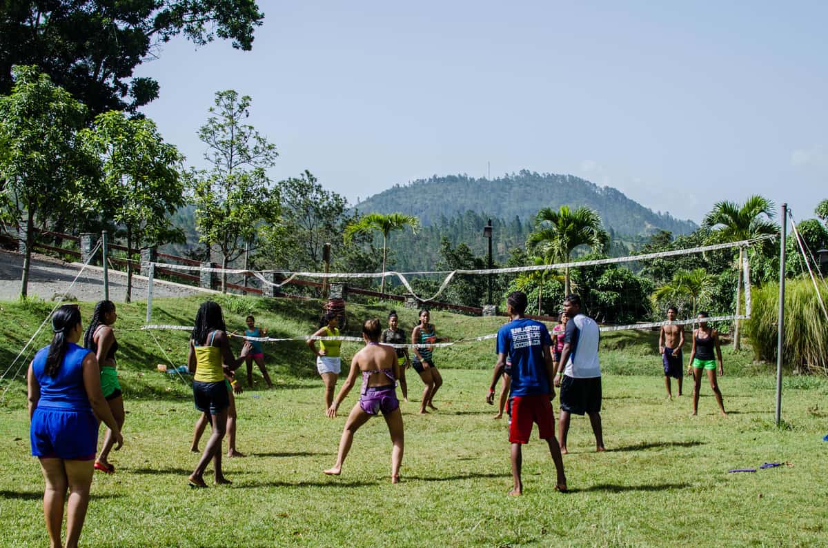 Teenagers playing an active net game on a lawn