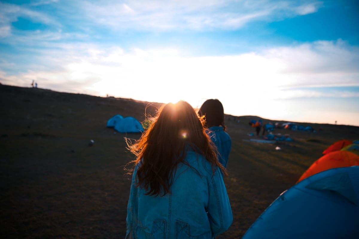 A campsite with tents at dusk and people gathered outside