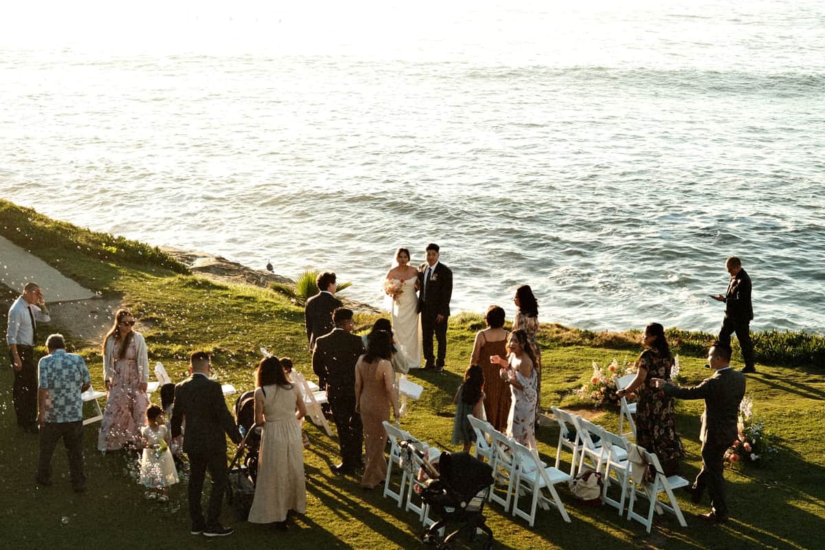 Guests on a lawn at an outdoor wedding reception