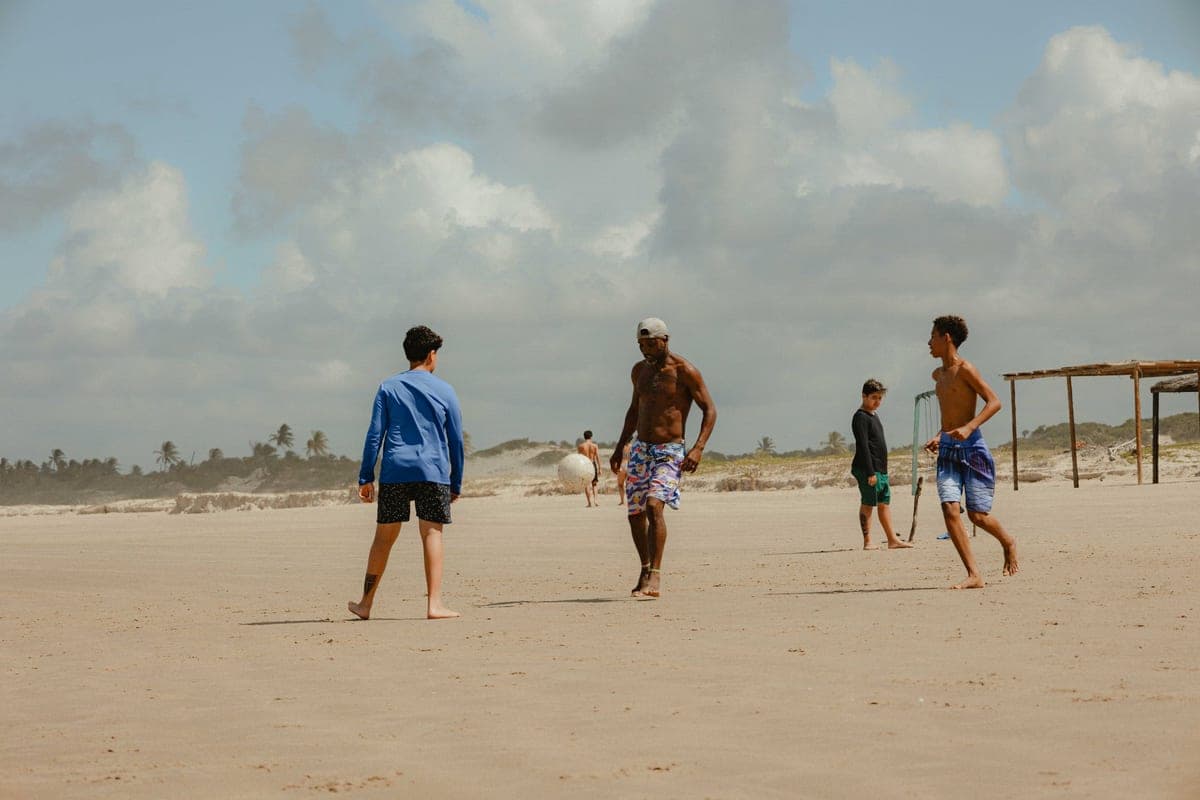 Friends playing a game on a sandy beach in summer